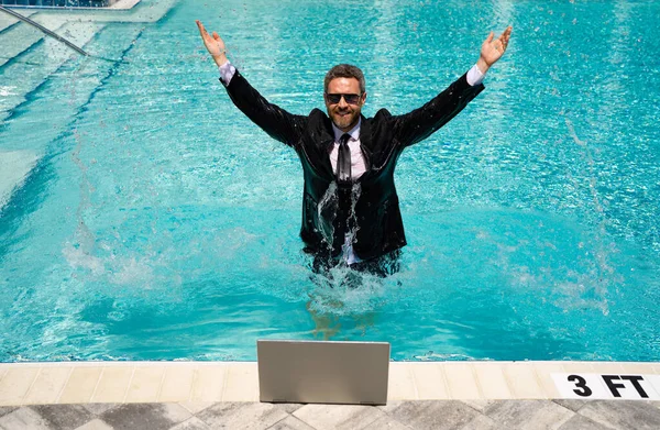 happy businessman has freelance business with laptop. photo of businessman has freelance business in pool. businessman has freelance business online. businessman has freelance business in pool.