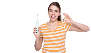 Beyaz arka planda elektrikli diş fırçası olan mutlu genç bir kadın. Tamam.