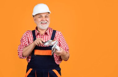 Sarı arka planda kasklı, olgun bir adam..