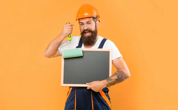 Cheerful Bearded Man Helmet Work Clothes Hold Paint Roller Blackboard — Stockfoto