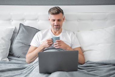 Olgun bir adamın laptopta kahve ile birlikte çalışmasına sevindim..