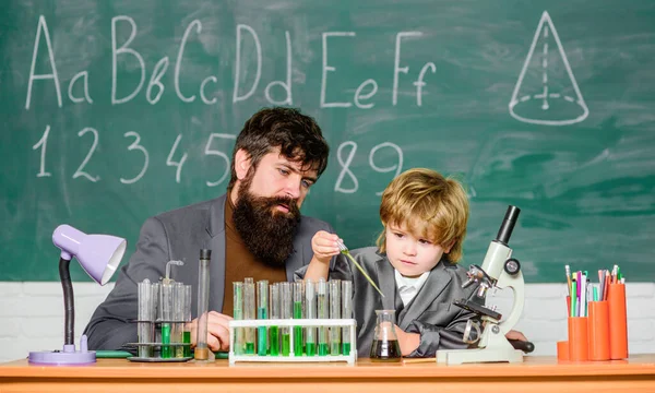 laboratory research and development. father and son child at school. bearded man teacher with boy. lab test tubes and flasks with colored liquids Chemistry experiment. Chemistry come as you are.