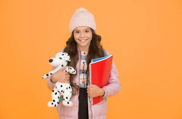 Care and treatment of animals. Studying veterinary medicine. Happy child hold toy dog and books. Little girl smile with soft toy. School classes. Toy dog. Learn and play. School and education.