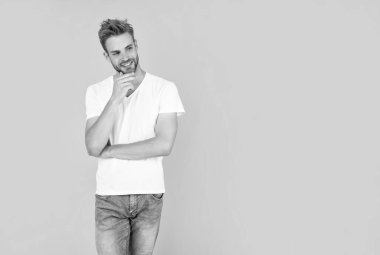 Beyaz gömlekli kıllı adam. Sarı arka planda sakallı genç bir adam. Saç ve sakal bakımı. Kendine güvenen ve yakışıklı, tıraşsız adam. Erkek modası. Erkeklerin güzelliği.