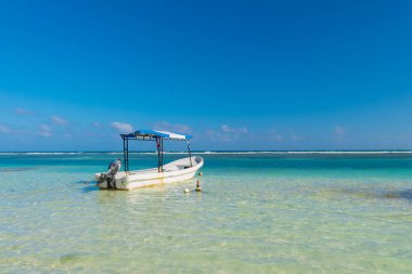 Plajda beyaz deniz teknesiyle yaz tatili. Seyahat teknesiyle yaz tatili. Deniz teknesiyle yaz tatilinin fotoğrafı. Deniz teknesiyle yaz tatili.