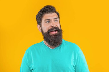 Arka planda şaşırmış sakallı adamın portresi. Sakallı adamın portresi. Sarıda izole edilmiş sakallı adamın portresi. Stüdyoda sakallı adamın portresi.