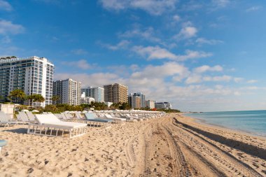 Yaz mevsiminde deniz manzaralı ve güneşli bir sahil. Yaz tatilinde güneş yatağı. Yaz plajında güneşlenirken çekilmiş bir fotoğraf. Yaz kumsalında güneş yatağı.