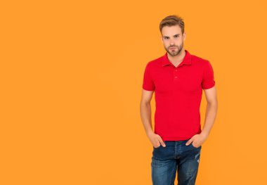 Kırmızı gömlekli kıllı adam. Sarı arka planda sakallı, kopyalama alanı olan genç bir adam. Saç ve sakal bakımı. Kendine güvenen ve yakışıklı, tıraşsız adam. Erkek modası. Erkeklerin güzelliği.