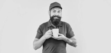 Kırmızı şapkalı ve tişörtlü mutlu sakallı adam elinde bardak sarısı arka plan, kahve.