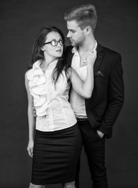 formal fashionable couple in love in business look on black background, colleague.