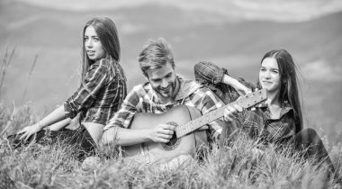 Müzik eşliğinde yürüyüş yapan arkadaşlar. Sadece arkadaşlar ve gitarlar. Yakışıklı adam gitar çalarken insanlar dağın tepesinde dinleniyor. Yürüyüş eğlencesi. Huzurlu bir yer. Doğanın melodisi. Yürüyüş geleneği.