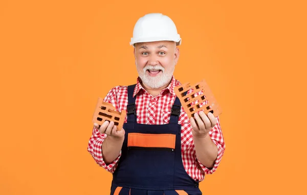 Fröhlicher Alter Mann Arbeiter Mit Helm Auf Gelbem Hintergrund — Stockfoto