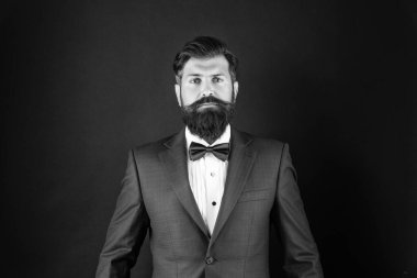 serious man in tuxedo bowtie. butler in formalwear on black background. male formal fashion.