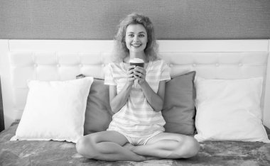 glad woman with morning coffee in bed. good morning. woman with coffee cup. woman hold coffee in the morning.