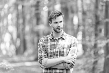 Ormanda beyaz adam tarzında çekilmiş bir fotoğraf. Açık havada beyaz bir adam. Beyaz adamın sakalı var. Kareli gömlek giyen beyaz bir adam..