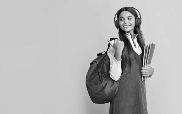 Glückliches Mädchen Mit Kopfhörer Und Schulrucksack Mit Arbeitsmappe Auf Gelbem — Stockfoto