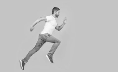 Energetic man running. Guy runner running on studio yellow background. Dynamic running, copy space.