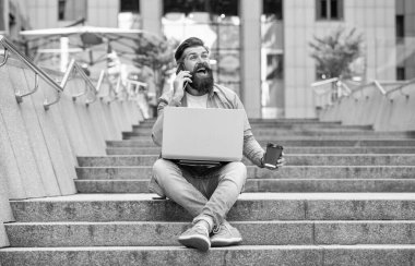 Dışarıda serbest iletişimi olan gülen adam. Açık havada serbest iletişimde olan bir adam. Serbest çalışan bir adam telefonda konuşuyor. Dizüstü bilgisayarında serbest iletişimi olan bir adam..