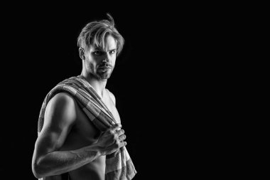 Üstsüz, kaslı, havluyla fotokopi çeken adam. Gömleksiz bir adamın kaslı kasları olduğu fotoğraf. Siyah arka planda havlusu olan kaslı üstsüz bir adam. Gövdesi kaslı, üstsüz bir adam.