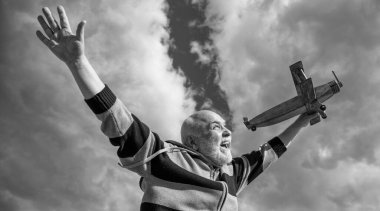 Emekli kıdemli bir adamın mutluluğu. Emekli olmuş olgun bir adam. Gökyüzündeki yaşlı adam oyuncak uçağıyla dışarıda.