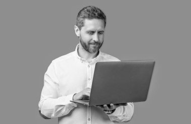 businessman freelance typing on pc isolated on blue background. businessman freelance in studio. businessman freelance with computer. businessman freelance holding laptop.