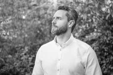 Handsome businessman man looking aside natural background.