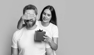 Sarı arka planda sürpriz hediyeli çift var. Sürpriz çift stüdyoda. Noel kutulu tatil çifti. Bayram sürprizi için hediyeli bir çift fotoğrafı. Erkekler Günü.