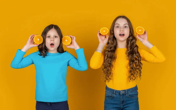 Staunende Teenager Kinder Halten Orangefarbene Früchte Auf Gelbem Hintergrund — Stockfoto