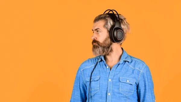 节奏的概念 男人留着胡子的嬉皮士耳机在听音乐 希斯特喜欢耳机中美妙的声音歌曲 优秀的音乐演奏家 噪声消除功能 专业的小玩意 音乐节拍 — 图库照片