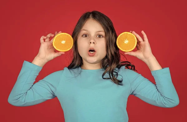 Σοκαρισμένος Έφηβος Παιδί Κρατώντας Πορτοκαλί Φρούτα Μωβ Φόντο — Φωτογραφία Αρχείου