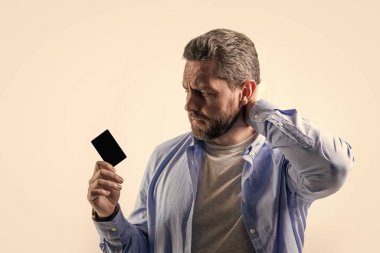 sad guy show business debit isolated on studio background. guy with business debit in studio. guy holding business debit. photo of guy hold business debit.