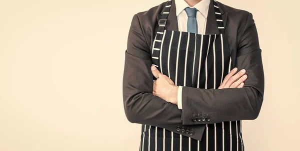 mature man crossed hands in suit and apron isolated on white background.