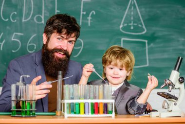 Empowered by Innovation. Little kid learning chemistry in school laboratory. Back to school. father and son at school. school kid scientist studying science. teacher man with little boy.