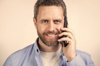 Stüdyoda iletişim kuran bir adamın portresi. İnsanoğlunun iletişim çağrısı. İletişim kuran bir adamın fotoğrafı. Adamın telefon görüşmesi var. Stüdyoda izole edilmiş..