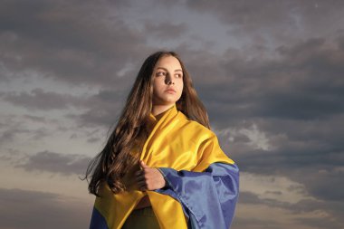 patriotic teen ukrainian kid with national flag of ukraine.