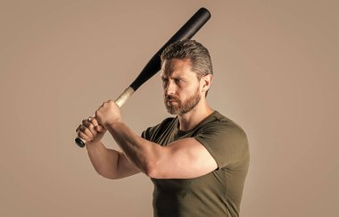 Kızgın adamın sopayla vurduğu fotoğraf. Kızgın adam tehdit ediyor. Öfkeli adam, gri arka planda izole edilmiş yarasayla öfkesini ifade eder. Stüdyoda sopalı kızgın adamın saldırganlığı..