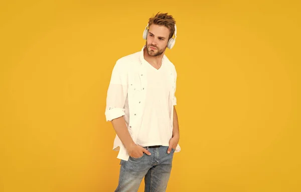 若い毛の男は黄色の背景で音楽を聞くファッション — ストック写真