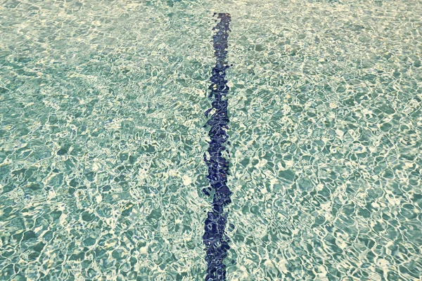青いスイミングプールの水の背景と線 — ストック写真