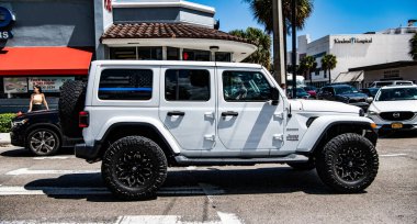 Miami, Florida ABD - 25 Mart 2023: beyaz 2018 Jeep Wrangler Sınırsız Sahra arabası yolda, yan görüş.