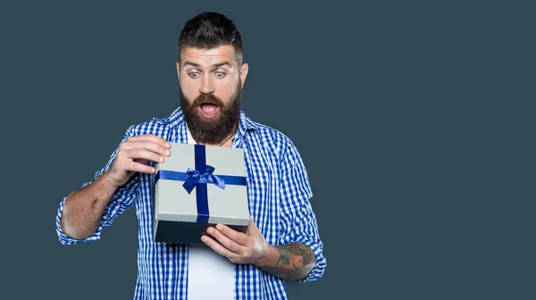 stock image amazed mature bearded guy with present box on grey background.