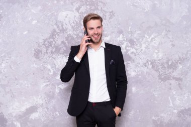 Grey 'de izole edilmiş neşeli, başarılı bir iş adamı konuşması. Stüdyoda iş adamı telefonda konuşur. İş adamı arka planda konuşur. İş adamının telefonda konuşurken çekilmiş fotoğrafı..