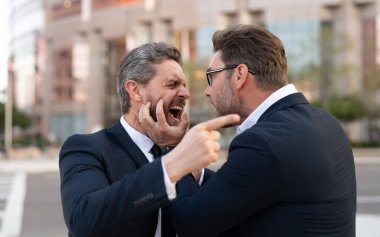 İki iş adamı arasında iş anlaşmazlığı var ve dışarıda birbirlerini suçluyorlar. Savaşan iş adamlarının iş anlaşmazlıkları vardır. İş adamlarının fotoğraflarında iş anlaşmazlığı var. İş adamlarında iş anlaşmazlığı var.