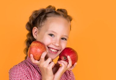 Neşeli çocuk meyve yer. Vitamin dolu. Gülümseyen çocuk kırmızı elmayı tutuyor. Vejetaryen diyeti. Sonbahar hasadı. Mutlu genç kız elmayı tutuyor. Mutlu ve sağlıklı bir çocukluk. Sağlıklı yemek ve yemek. Boşluğu kopyala.