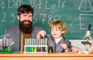 Laboratuvar test tüpleri ve renkli sıvılarla dolu mataralar. Baba ve oğul okulda. Laboratuvarda bilimsel araştırmalar yapan bir araştırmacı. Okula dönelim. Erkek erkeğe, erkek erkeğe. Yenilik bizimle başlar..