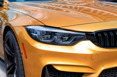 Miami Beach, Florida USA - 15 Nisan 2021: Sarı BMW M4 arabasının ön lambası.