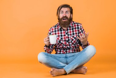 Şaşırtıcı sakallı, sakalsız, şık saçlı, sıradan kıyafetler giyen, kahve içen yakışıklı bir adam..