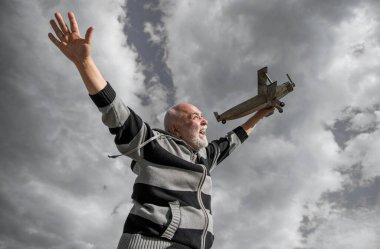 Emekli kıdemli bir adamın özgürlüğü. Emekli olmuş olgun bir adam. Gökyüzündeki yaşlı adam oyuncak uçağıyla dışarıda.