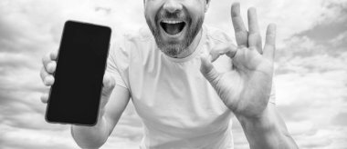 Akıllı telefon ekranı ile fotokopi alanı sunan adamın kırpılmış görüntüsü. Tamam.