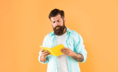 curious bearded man with planner on yellow background, daily planning.