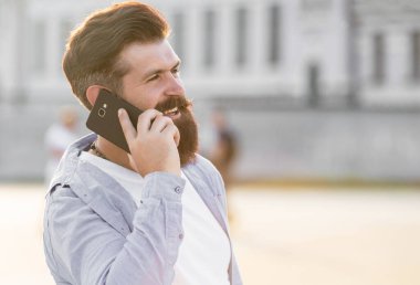 Adam açık havada akıllı telefondan konuşur, uzayı taklit eder. Adam dışarıda akıllı telefondan konuşuyor. Adam sokakta akıllı telefondan konuşuyor. Akıllı telefondan konuşan adamın fotoğrafı..